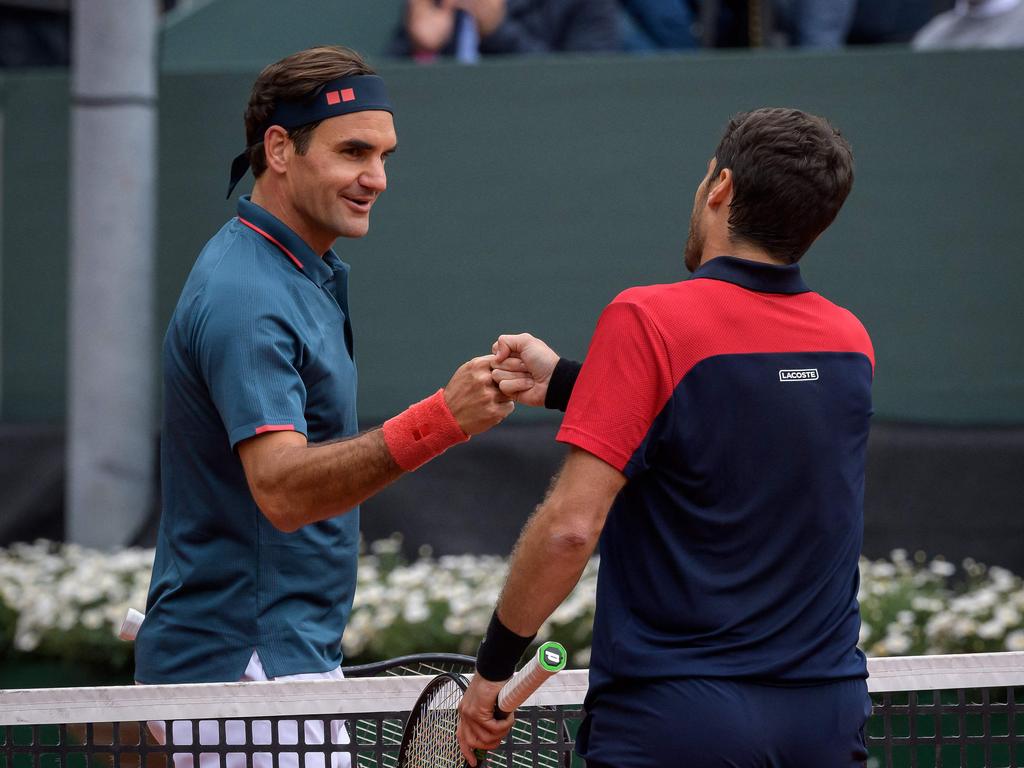 Roger Federer bumps fists with Spain's Pablo Andujar after losing his ATP 250 Geneva Open match on May 18. (Photo by Fabrice COFFRINI / AFP)