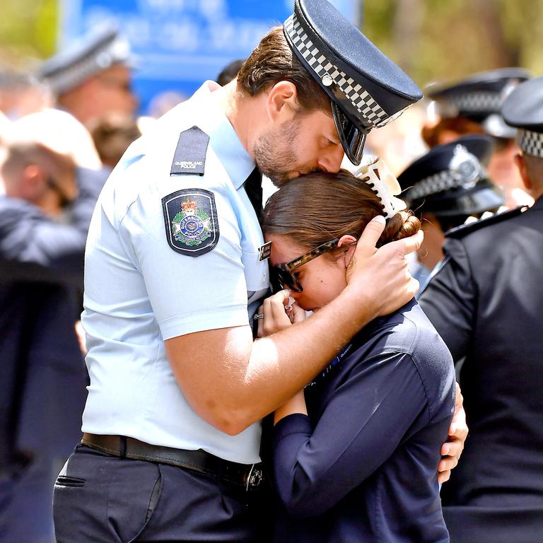 A pair of police officers hug eachother at the funerals for Matthew Arnold and Rachel McCrow. Picture: John Gass