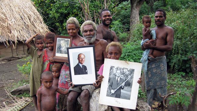 Chief Jack Naiva with some of his tribe members and his wife holding pictures of their 'god' Prince Philip.