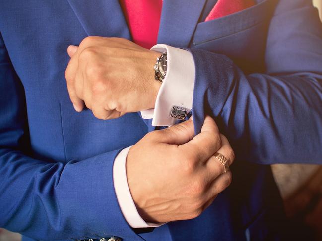 Elegant men's hand adjusting the cufflink