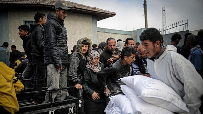 A Palestinian man transports sacks of humanitarian aid at the Rafa distribution centre in the southern Gaza Strip. Picture: AFP