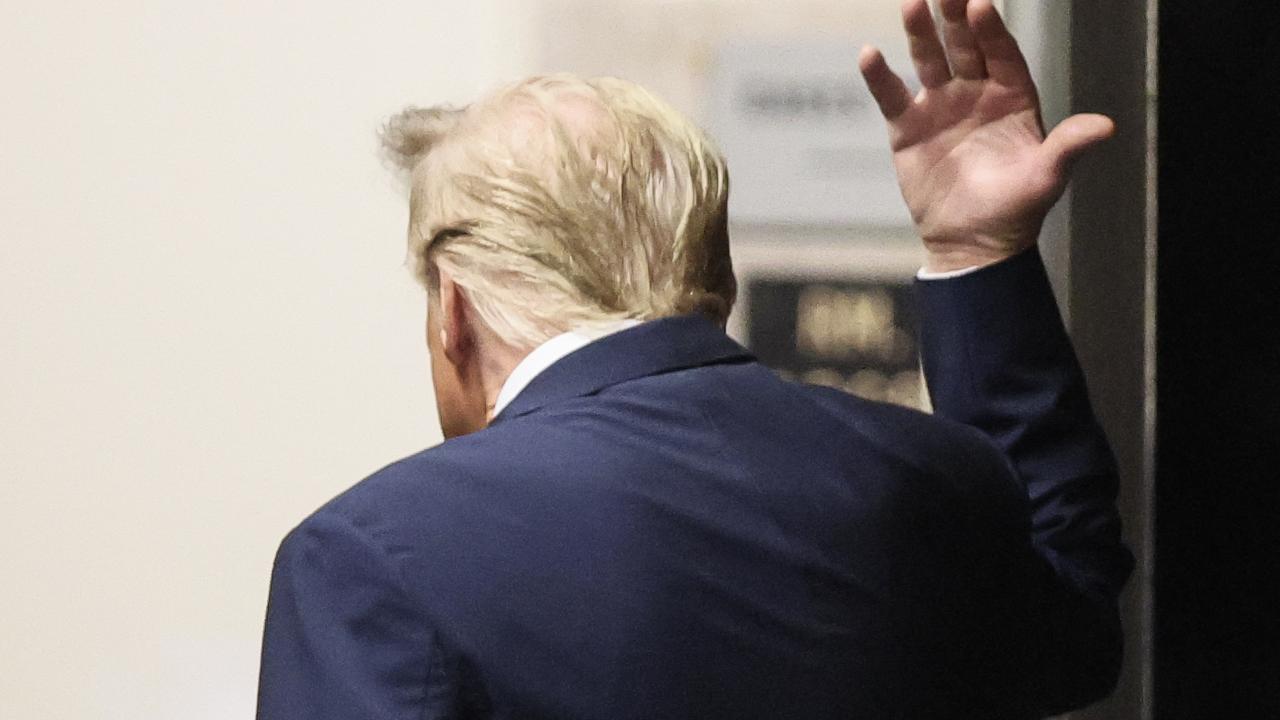 Donald Trump gestures while walking in a hallway outside the courtroom after the gag order arguments on April 23. (Photo by Brendan McDermid / POOL / AFP)