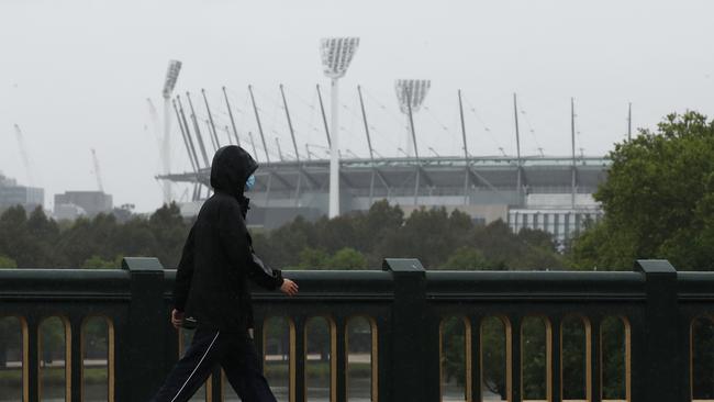 A person walks along the Princes Bridge overlooking the MCG in Melbourne, Victoria during summer. Picture: NCA NewsWire / Daniel Pockett