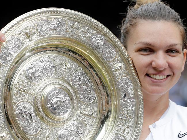 Romania's Simona Halep poses with the Venus Rosewater Dish trophy after beating US player Serena Williams during their women's singles final on day twelve of the 2019 Wimbledon Championships at The All England Lawn Tennis Club in Wimbledon, southwest London, on July 13, 2019. (Photo by Ben Curtis / various sources / AFP) / RESTRICTED TO EDITORIAL USE