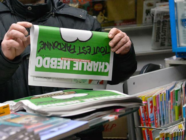 Popular ... a man buys a copy of the new edition of Charlie Hebdo magazine at a Pigalle newsstand in Paris, France. Three million copies of the controversial magazine have been printed so far. Picture: Aurelien Meunier/Getty Images