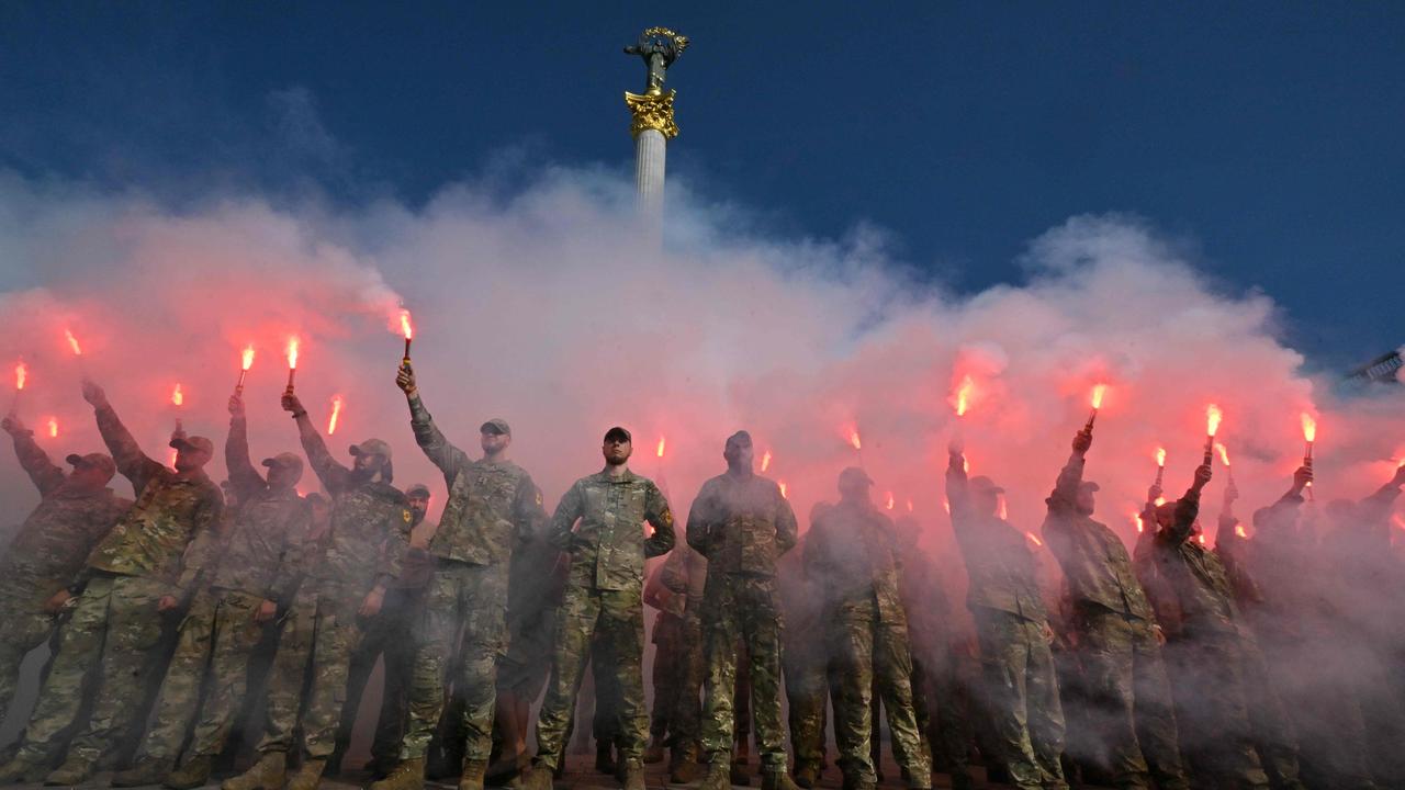 Servicemen of Ukrainian Azov Brigade burn flares during a memorial event at Independence Square in Kyiv on July 28. Picture: Sergei Supinsky/AFP