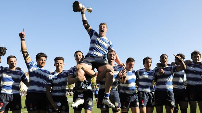 Nudgee captain Harry Vella is lifted from the field with the trophy after last year’s success. Picture: Mark Cranitch