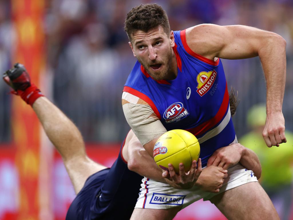 Marcus Bontempelli clears by hand as he is tackled by Jack Viney. Picture: Michael Klein