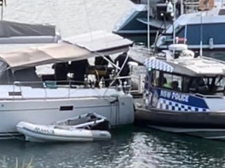 Police officer remove one of the bodies off the boat. Picture: Madeleine Damo