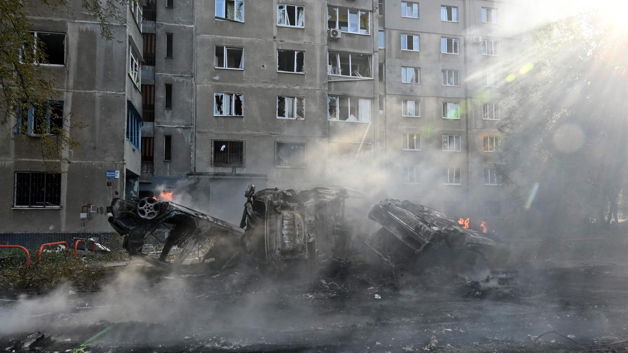 Burnt-out cars are seen in the courtyard after the strike. Picture: Sergey Bobok/AFP