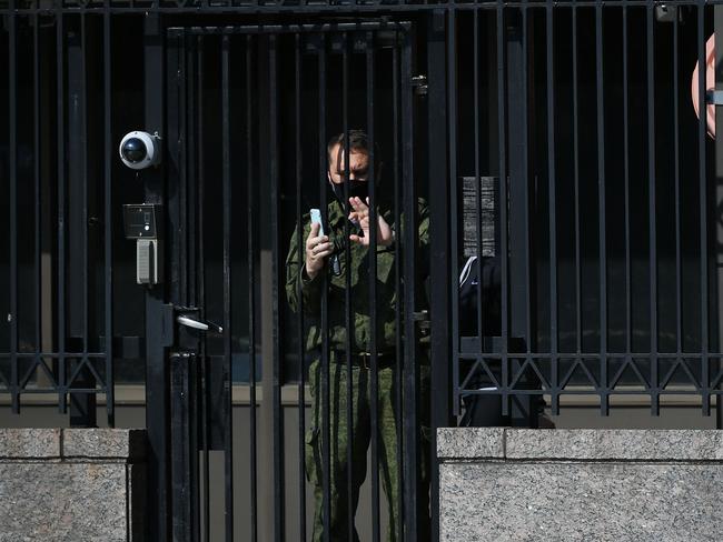 A security guard at the Russian Embassy in Washington, DC, aims his phone camera at media gathered outside on Thursday. Picture: AFP