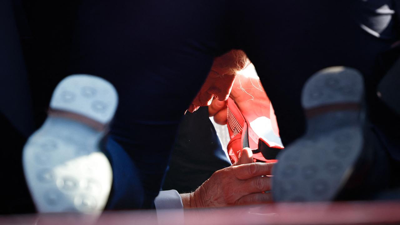 The former president dives for cover as blood flows from his right ear. Picture: Getty Images