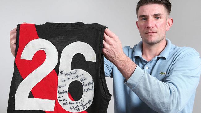 Mark Hardy with Mark ‘Bomber’ Thompson’s 1984 premiership jumper. Picture: Ian Currie