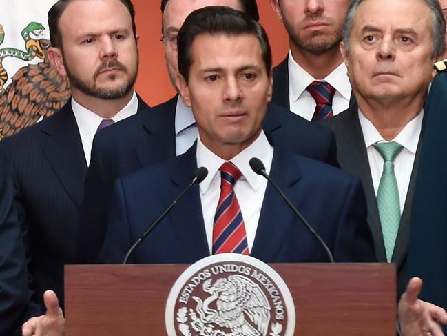 Mexican President Enrique Pena Nieto (R), accompanied by his cabinet, speaks during a press conference offered along with President-elect Andres Manuel Lopez Obrador (out of frame) during a ceremony in which the latter presented his own cabinet, at the National Palace in Mexico City, on August 20, 2018. (Photo by Alfredo ESTRELLA / AFP)