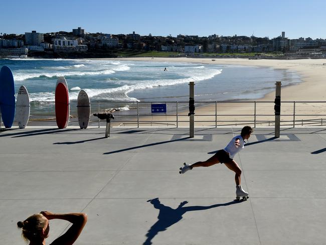 A woman rollerskates in front of a closed Bondi Beach in Sydney. Picture: AAP