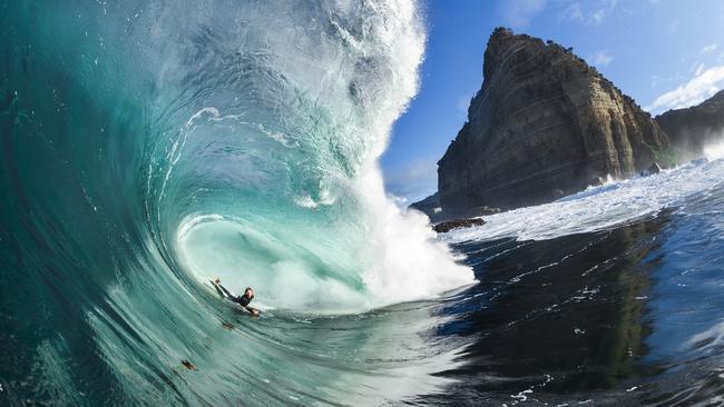 Surfer Harley Ward taking the perfect line through a beautiful Shipstern Bluff wave, with the unique Bluff in full view. For TasWeekend story about a new book by surfer Marti Paradisis called When the Ocean Awakens. Picture: Mat Tildesley