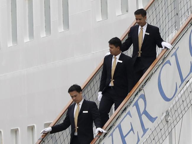 Silver Cloud porters descend a staircase to help carry the luggage of Team USA.