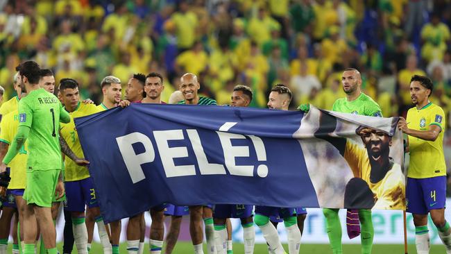 Brazil players hold a banner showing support for former Brazil player Pele