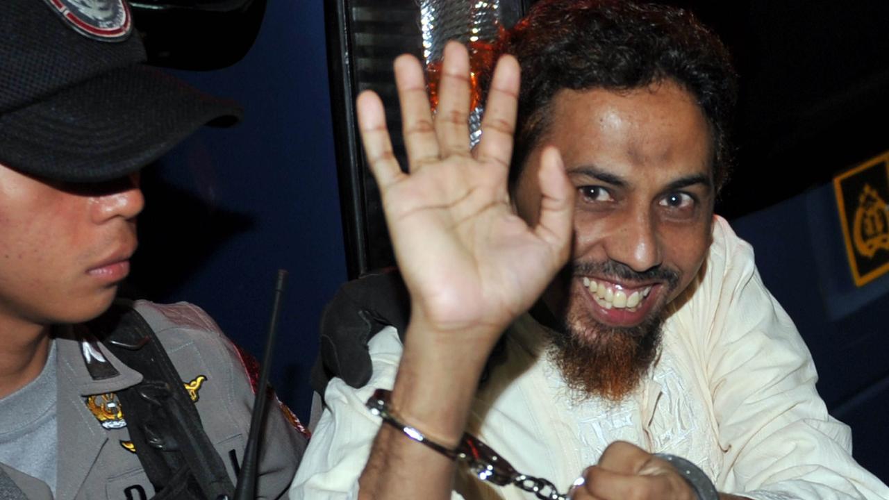 Umar Patek waves to journalists as he arrives at the West Jakarta Court in 2012.