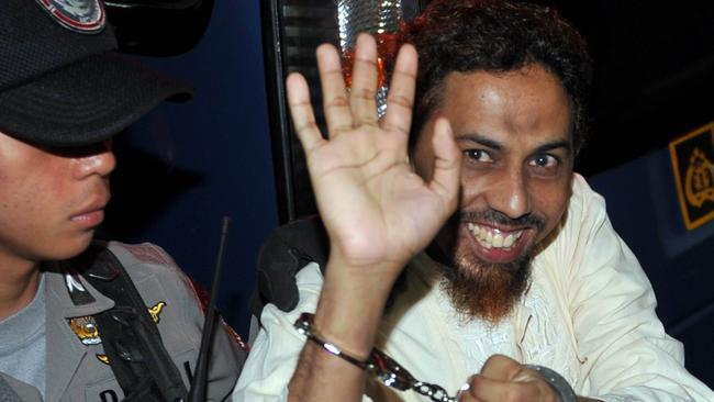 Umar Patek waves to journalists as he arrives at the West Jakarta Court in 2012.