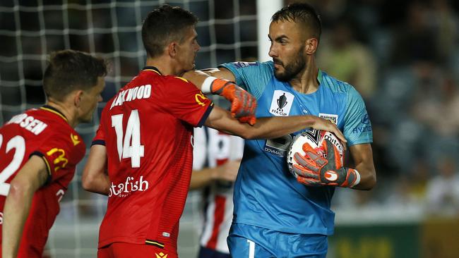 Central Coast goalkeeper Mark Birighitti swings his elbow at Adelaide United forward George Blackwood during the FFA Cup last four clash. Picture: AAP Image/Darren Pateman