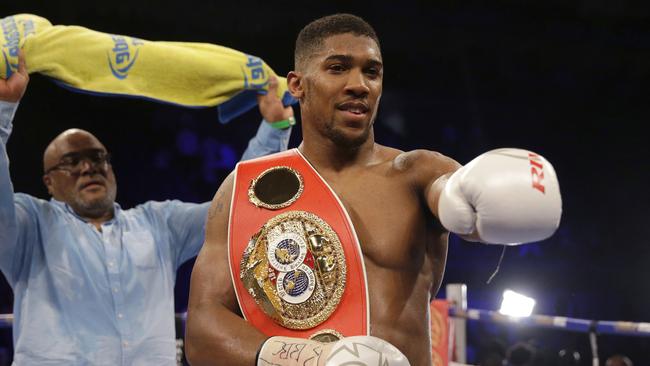 British boxer Anthony Joshua holds his belt fanned by his father Robert after defeating U.S. boxer Dominic Breazeale in their IBF heavyweight title bout.