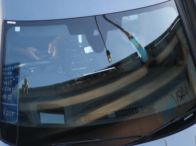 Father like son a male driver with a male school child passenger both using a phone. Picture: John Grainger