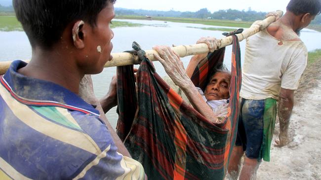 Rohingya refugees carry and an old woman from Rakhine state in Myanmar along a path near Teknaf in Bangladesh on September 3, 2017. Picture: R. Asad