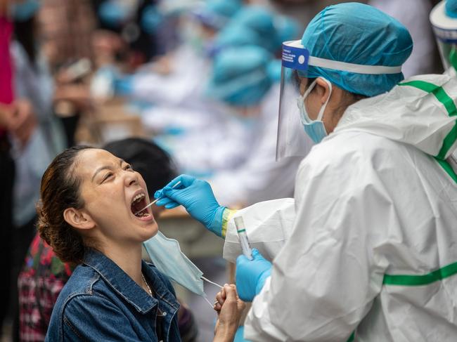 A medical worker takes a swab sample from a resident to be tested for the COVID-19 coronavirus, in a street in Wuhan, China. Picture: AFP