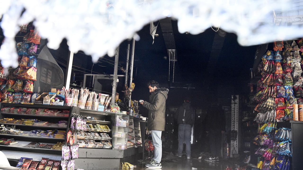 Staff inspect the fire damaged interior of Harry Mart on Chapel Street Prahran after an early morning arson attack. Picture: NCA NewsWire / Andrew Henshaw