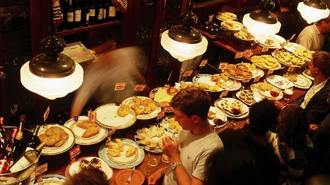 Patrons enjoy pintxos at a bar in San Sebastian.