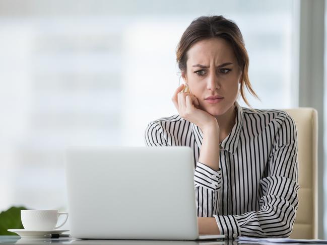 Confused businesswoman annoyed by online problem, spam email or fake internet news looking at laptop, female office worker feeling shocked about stuck computer, bewildered by scam message or virus