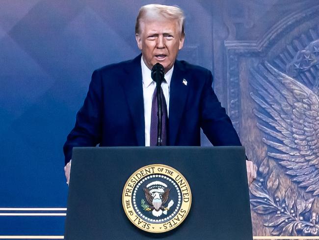 US President Donald Trump is seen on a giant screen during his address by video conference at the World Economic Forum (WEF) annual meeting in Davos on January 23, 2025. (Photo by Fabrice COFFRINI / AFP)