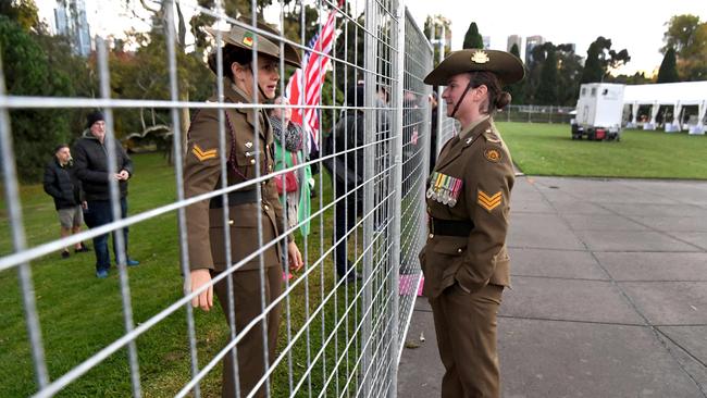 Two soldiers chat through a fence after the Anzac Day Dawn Service. Picture: William West/AFP