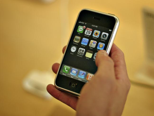 **FILE** A customer tries an iPhone in an Apple store, in this June, 29, 2007 file photo, in Seattle. Apple Inc. is expected to release quarterly earnings on Wednesday, July 25, 2007. (AP Photo/Andrei Pungovschi, file)