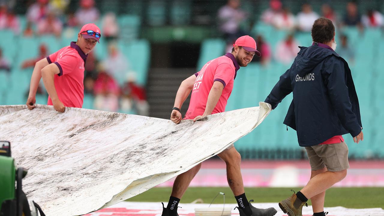 Groundstaff move the covers. Photo by Cameron Spencer/Getty Images