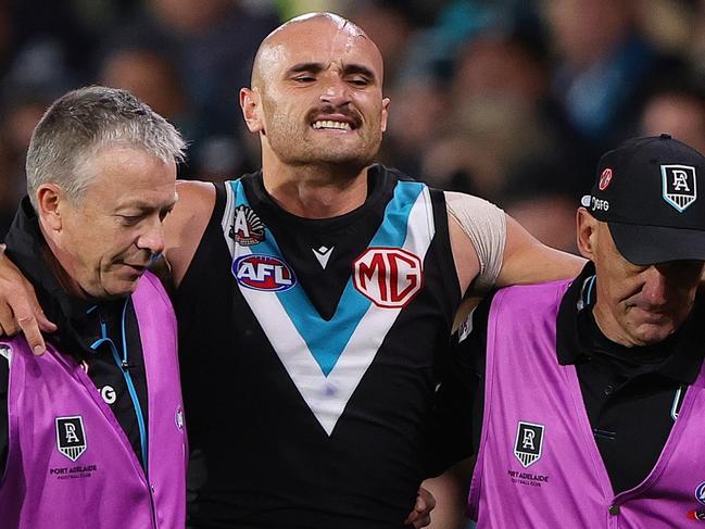 ADELAIDE, AUSTRALIA - APRIL 26: Sam Powell-Pepper of the Power in the hands of medical staff after hurting his knee during the 2024 AFL Round 07 match between the Port Adelaide Power and the St Kilda Saints at Adelaide Oval on April 26, 2024 in Adelaide, Australia. (Photo by Sarah Reed/AFL Photos via Getty Images)