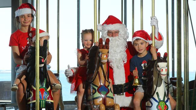 Monica, 10, Millie, 2 and Luke, 7, with Santa during his visit to the Carousel in Geelong, one of the many. Picture: Alison Wynd