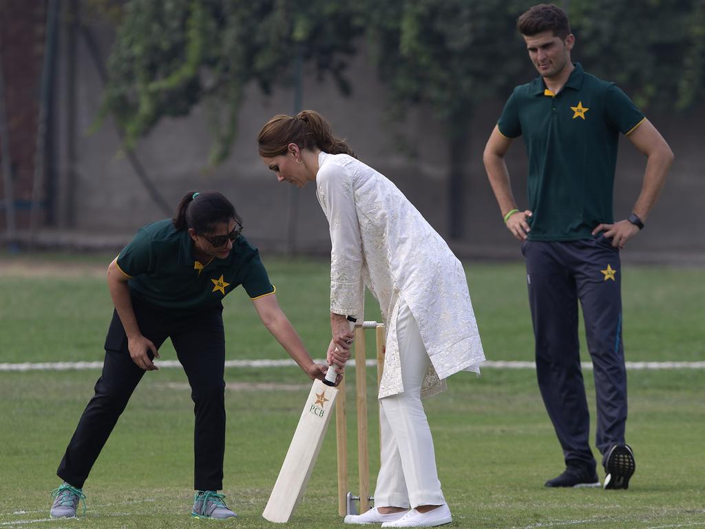 Sana Mir, captain of the Pakistan women's cricket team helps Britain's Kate, Duchess of Cambridge to hold a bat as Pakistani bowler Shaheen Afridi looks on. Picture: AP Photo