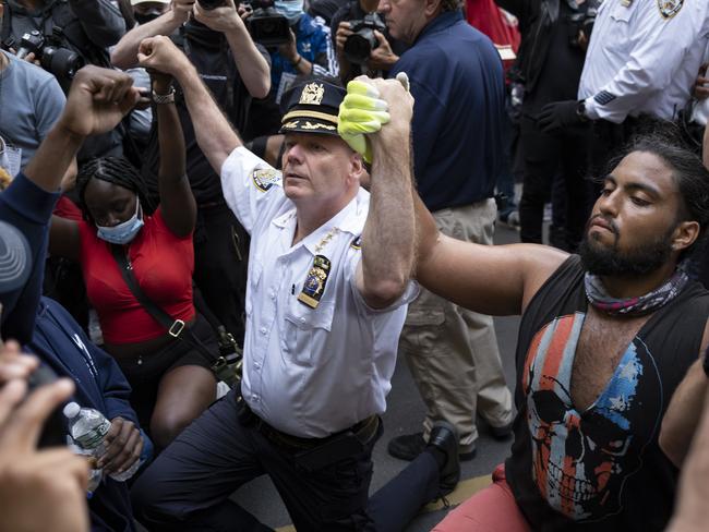 Chief of Department of the New York City Police, Terence Monahan, takes a knee with activists. Picture: AP