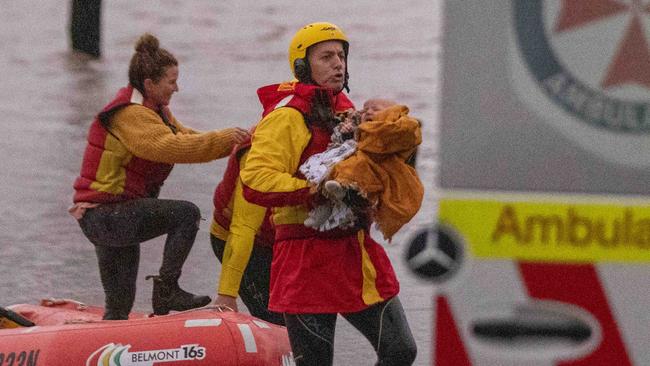 The baby let out a big cry once it was safe onshore in the arms of a life saver awaiting an ambulance. Picture: Liam Mendes / The Australian