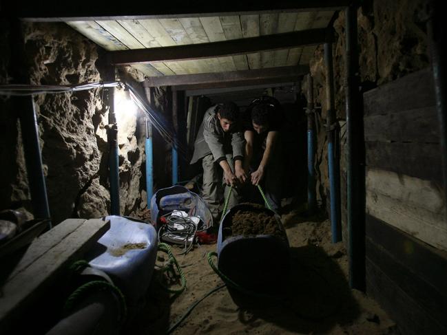 Palestinian men repair a smuggling tunnel, which was destroyed by Israel, in the border town of Rafah between Egypt and the southern Gaza Strip on January 22, 2009 Picture: MOHAMMED ABED / AFP