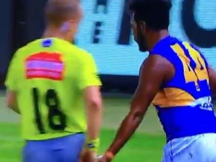 Willie Rioli taps umpire Ray Chamberlain on the backside