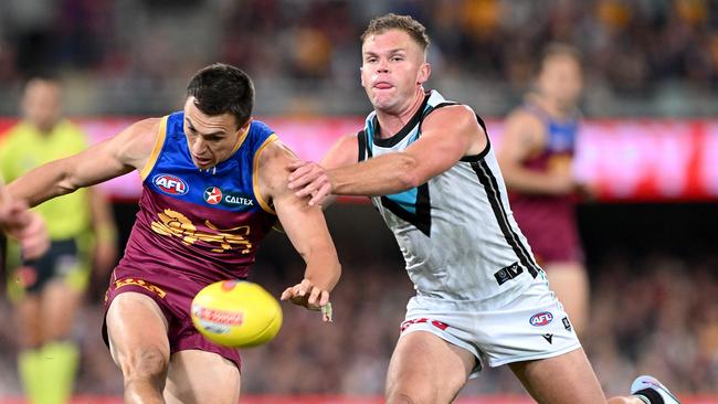 McCluggage kicks under pressure from Dan Houston. Picture: Bradley Kanaris/Getty Images