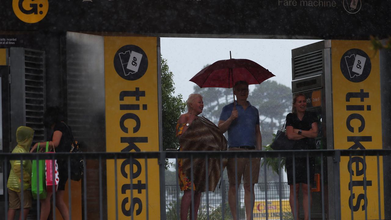 People look on at Broadwater Parklands Station on Queen St in Southport after a storm lashes the Gold Coast. Photograph : Jason O’Brien