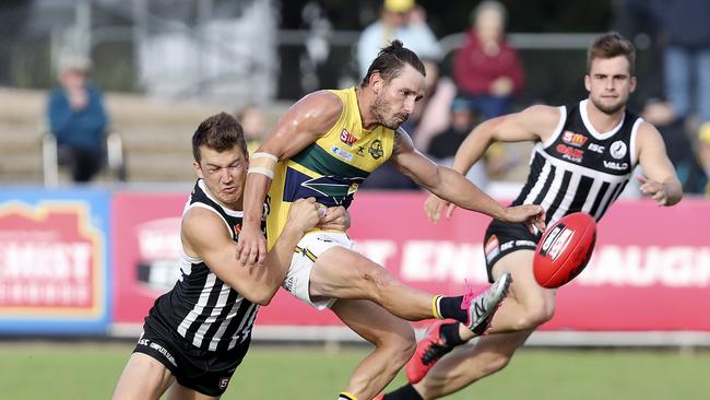 James Bond gets his kick away while being tackled by Port’s Jack Trengove. Picture: Sarah Reed