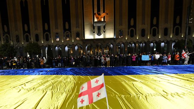 A demonstrator waves a flag of Georgia near a giant Ukrainian flag during a rally in support of Ukraine in Tbilisi on March 7. Picture: Vano Shlamov/AFP