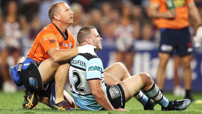 Wade Graham of the Sharks receives attention from the trainer after injuring his knee. Picture: Getty Images