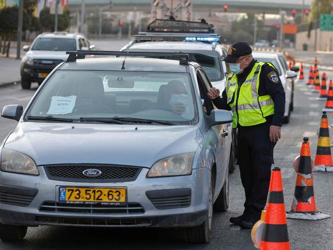 An Israeli policeman inspects a driver's papers at a checkpoint in Jerusalem, on September 19, to enforce lockdown after a spike in COVID-19 cases. Picture: AFP