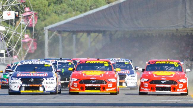 Supercars roar towards turn 1 at the start of race 1 at the Superloop Adelaide 500 2019. Jamie Whincup, Fabian Coulthard and Scott McLaughlin vie for first position. Picture: AAP/Brenton Edwards